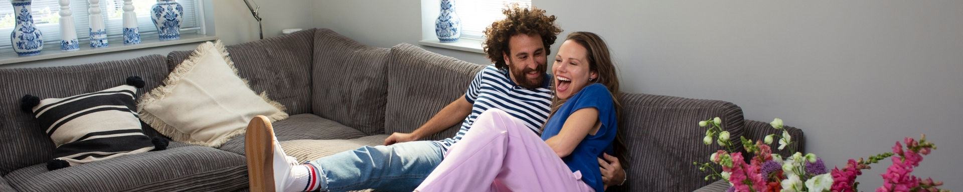 Man en vrouw zitten vrolijk op de bank